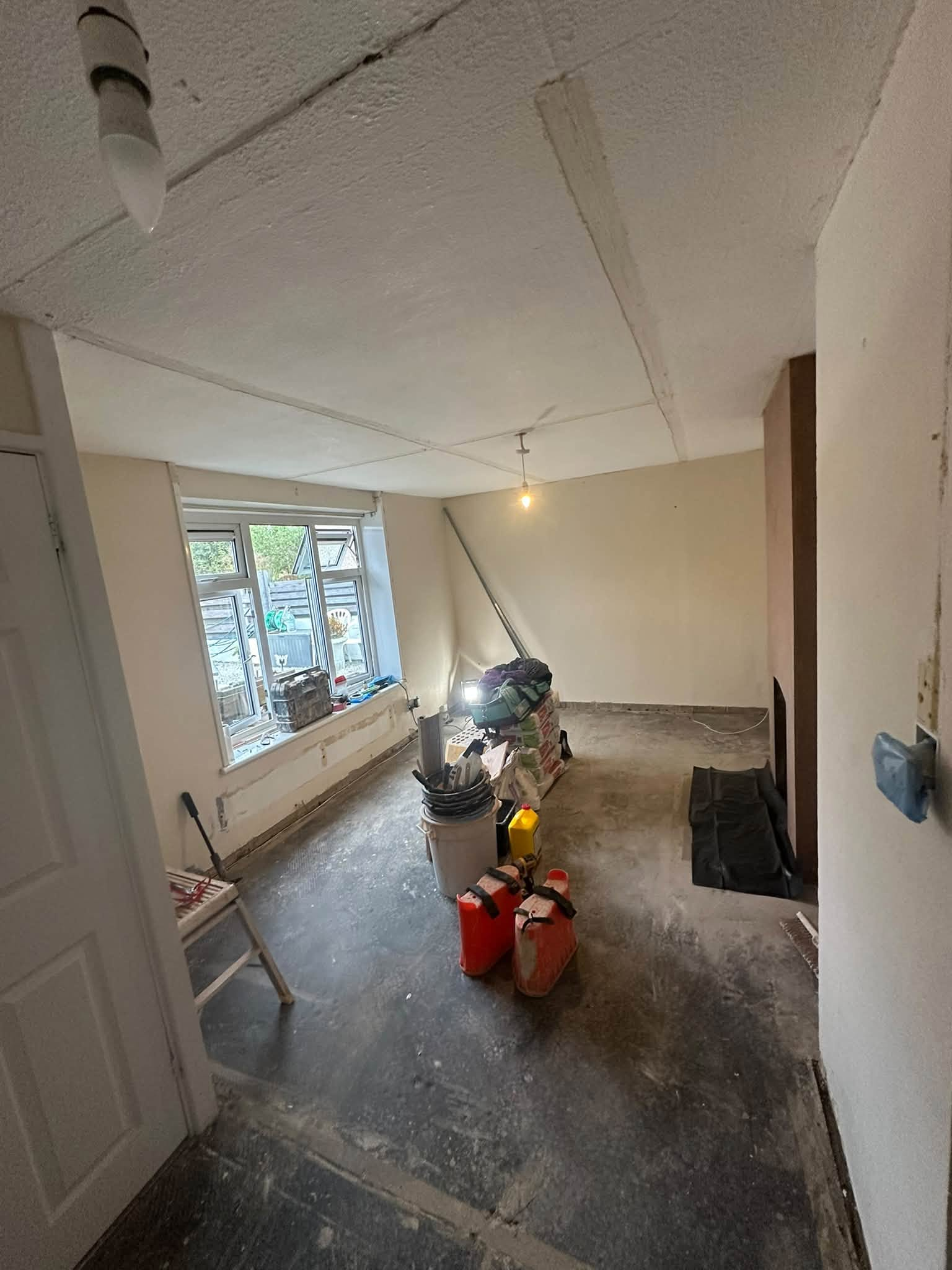 Room with a textured ceiling and equipment during preparation for plastering